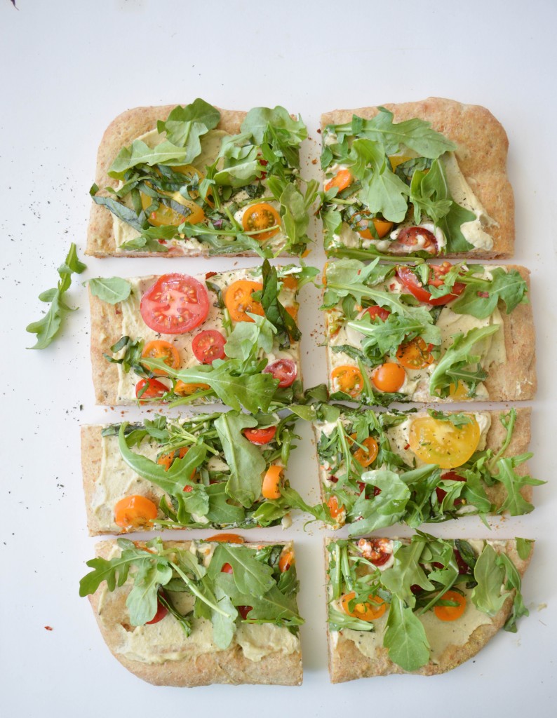 Sprouts and Chocolate: Cherry Tomato, Arugula and Herb Pissaladière with Roasted Garlic Cream Sauce. Dough does not have to intimidate you in the kitchen. This quick and easy dough is made in the food processor and doesn't take all day to rise. Corn meal crusted Pissaladière, topped with fresh summer produce, herbs and a rich roasted garlic cream sauce (made from cashews!). Veg and carnivore crowd pleasing recipe!